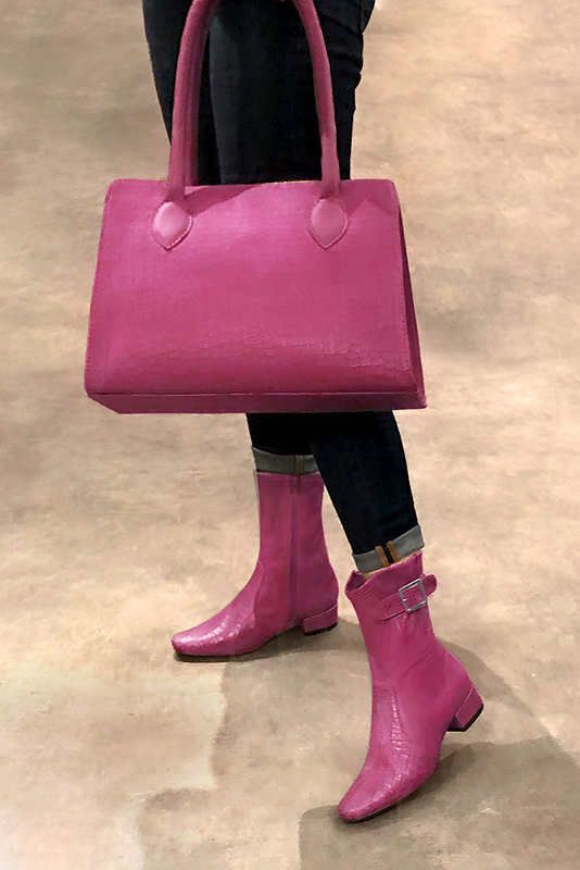 Fuschia pink women's ankle boots with buckles on the sides. Round toe. Low block heels. Worn view - Florence KOOIJMAN